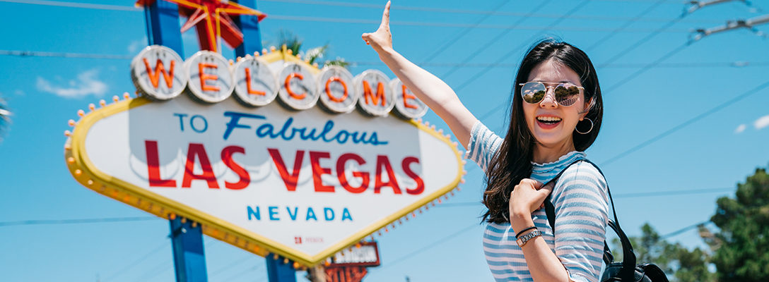 Woman Pointing to Welcome to Las Vegas Sign